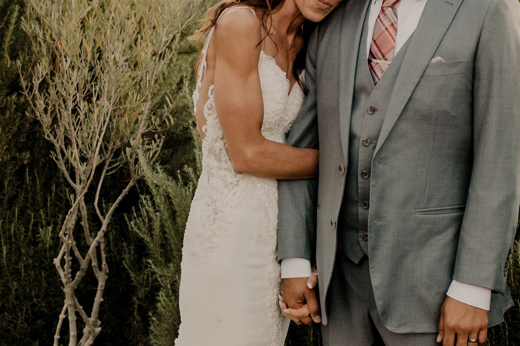 bride holding grooms arm during wedding photos