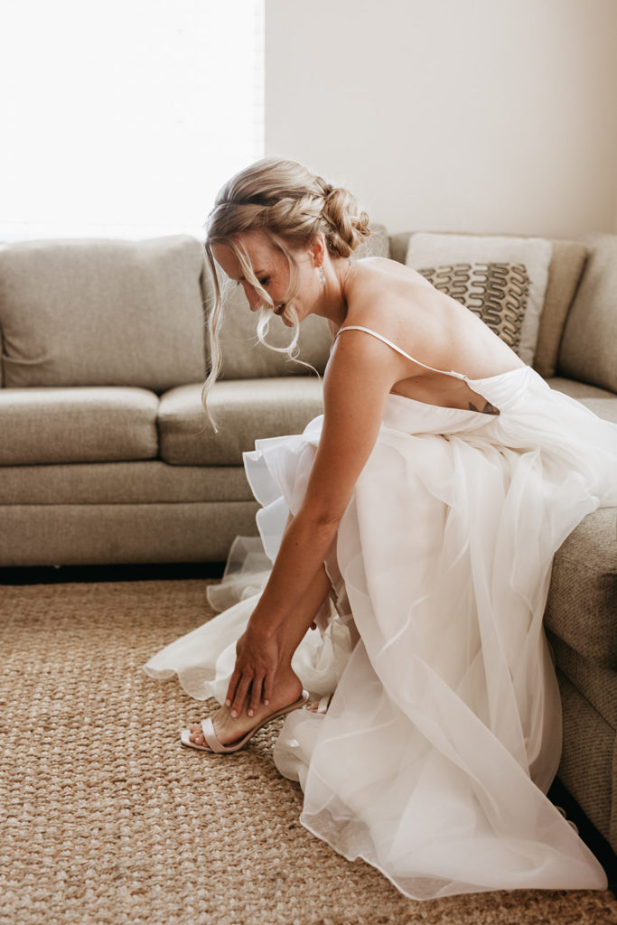 bride putting on her wedding shoes
