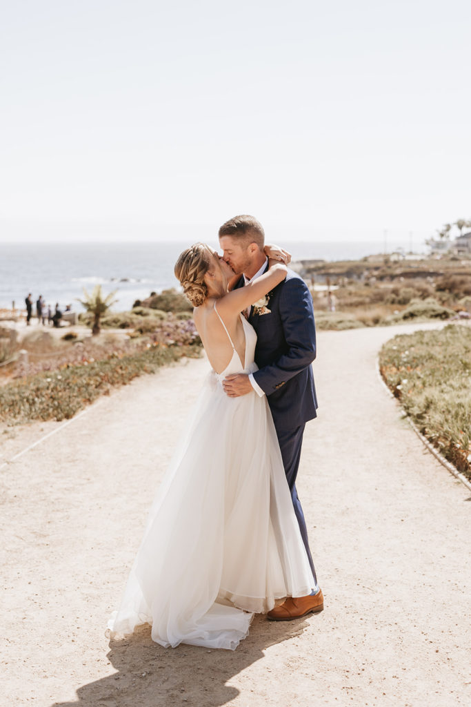 bride and groom kissing at pismo beach california