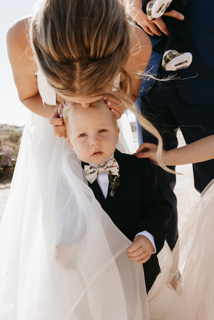 bride kissing her child at wedding pismo beach california