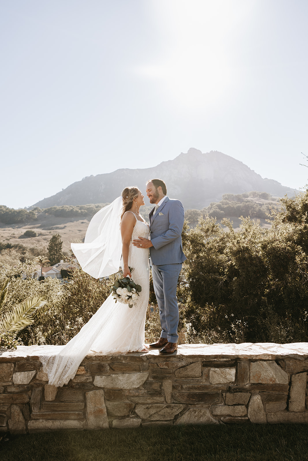 bride and groom walking on a ledge | The Penny: A Downtown Wedding Venue in San Luis Obispo