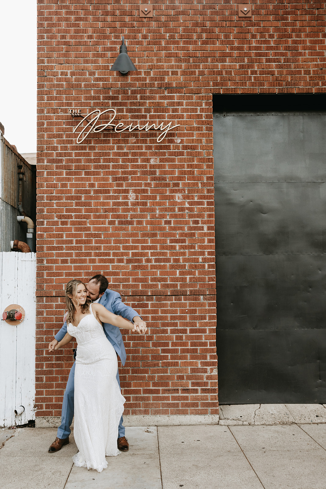 bride and groom standing outside of a brick building The Penny: A Downtown Wedding Venue in San Luis Obispo