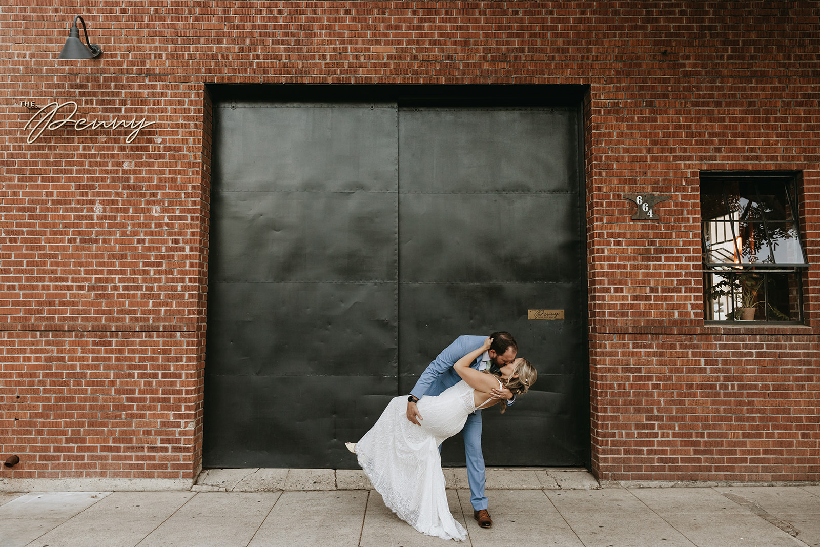 bride and groom posing in front of a brick wall | The Penny: A Downtown Wedding Venue in San Luis Obispo