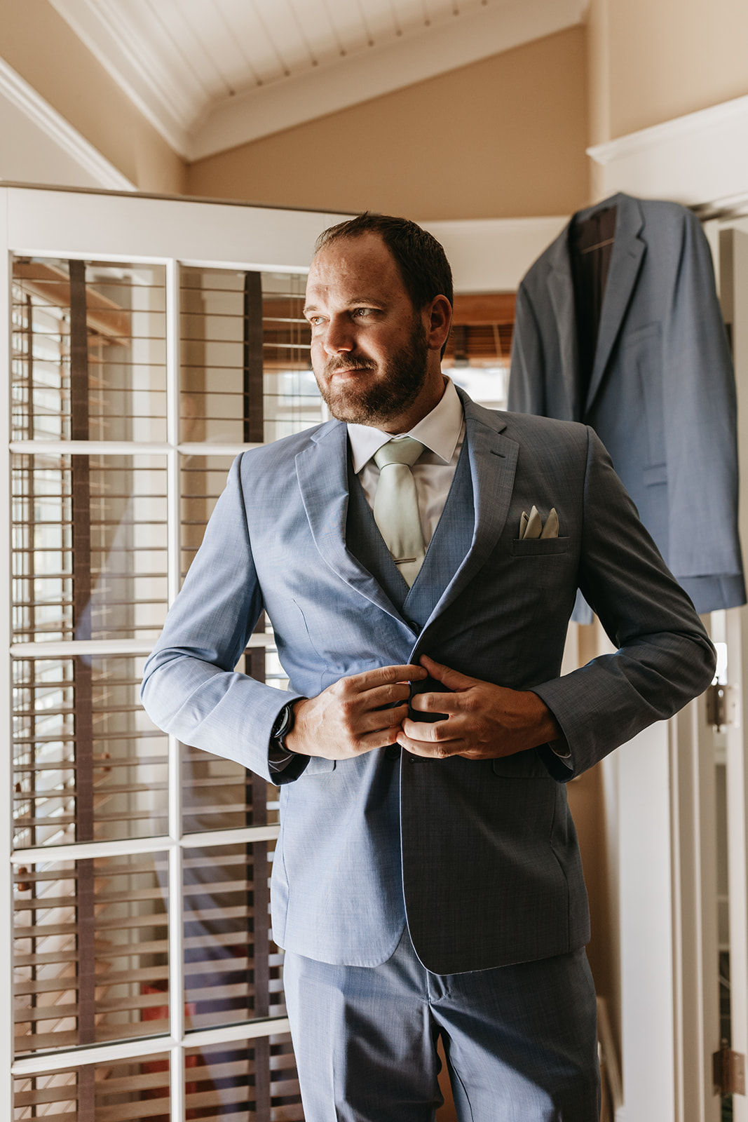 groom buttoning his suit |The Penny: A Downtown Wedding Venue in San Luis Obispo