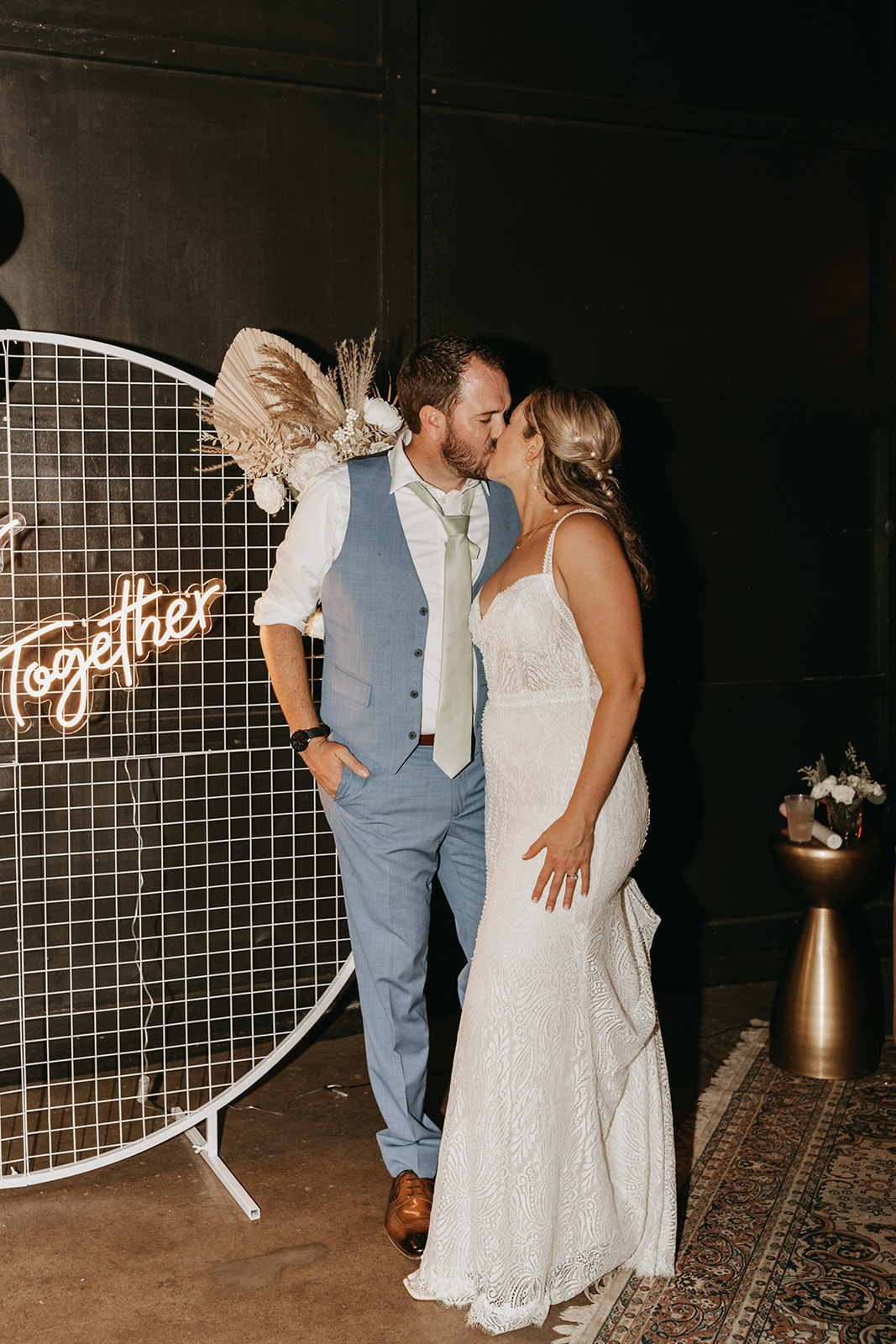 bride and groom kissing in front of a neon sign | The Penny: A Downtown Wedding Venue in San Luis Obispo