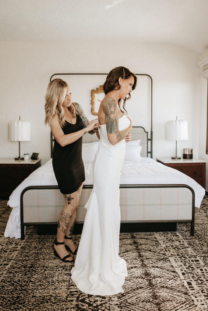 bride getting her dress zipped up for her elopement | An Outdoor Santa Barbara Courthouse Wedding Elopement | Brandi & Allen