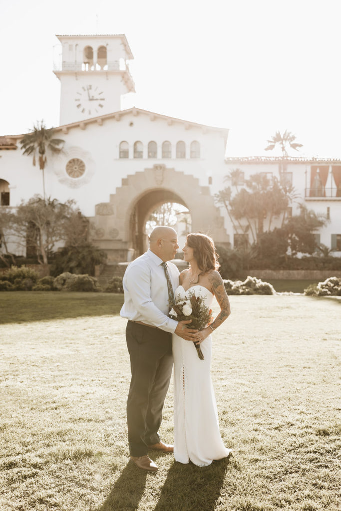 new bride and groom posing after their courthouse elopement in santa Barbara.