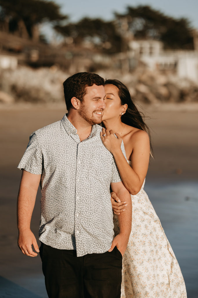 couple walking and posing on the beach after their engagement 