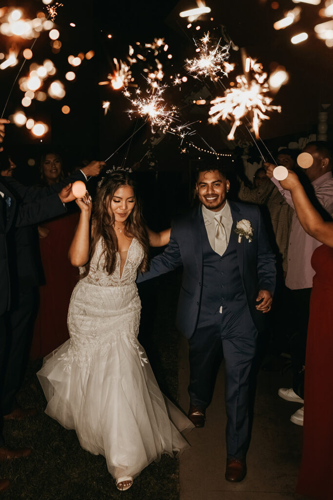 bride and groom posing for their wedding exit photos