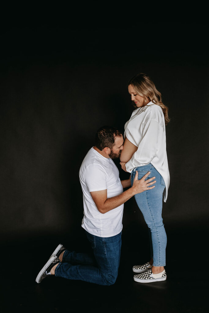 a couple posing for their maternity photoshoot to celebrate a lifetime milestone