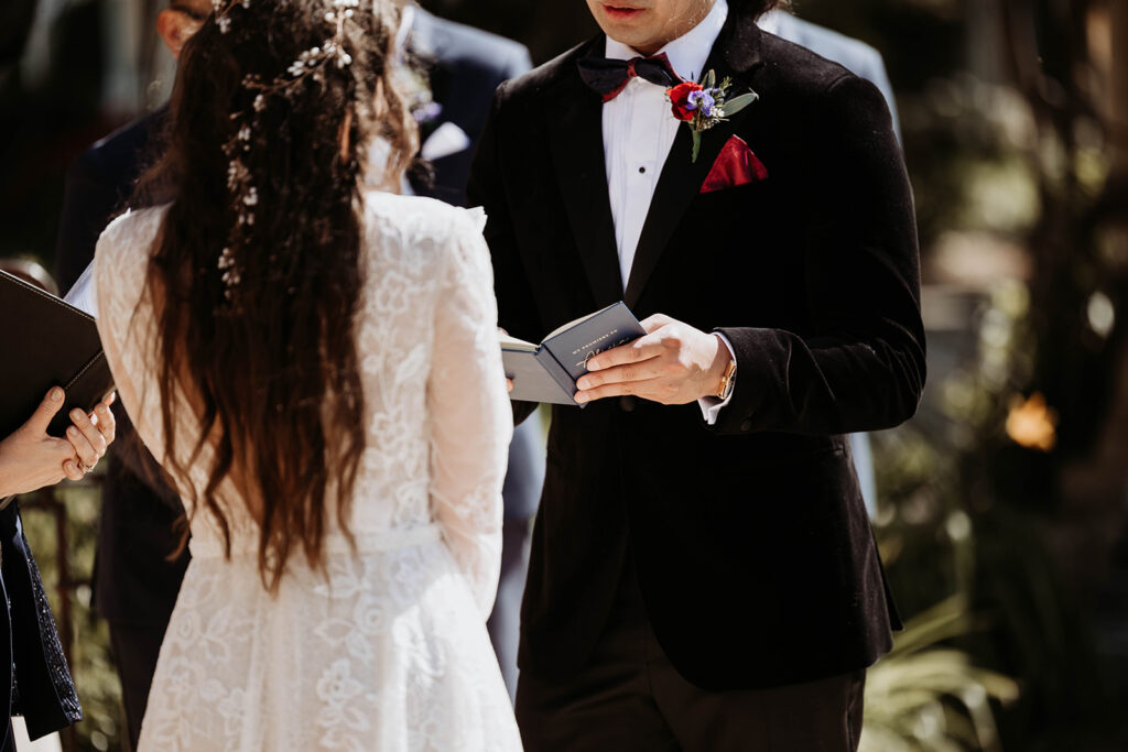 bride and groom during their wedding ceremony reading vows