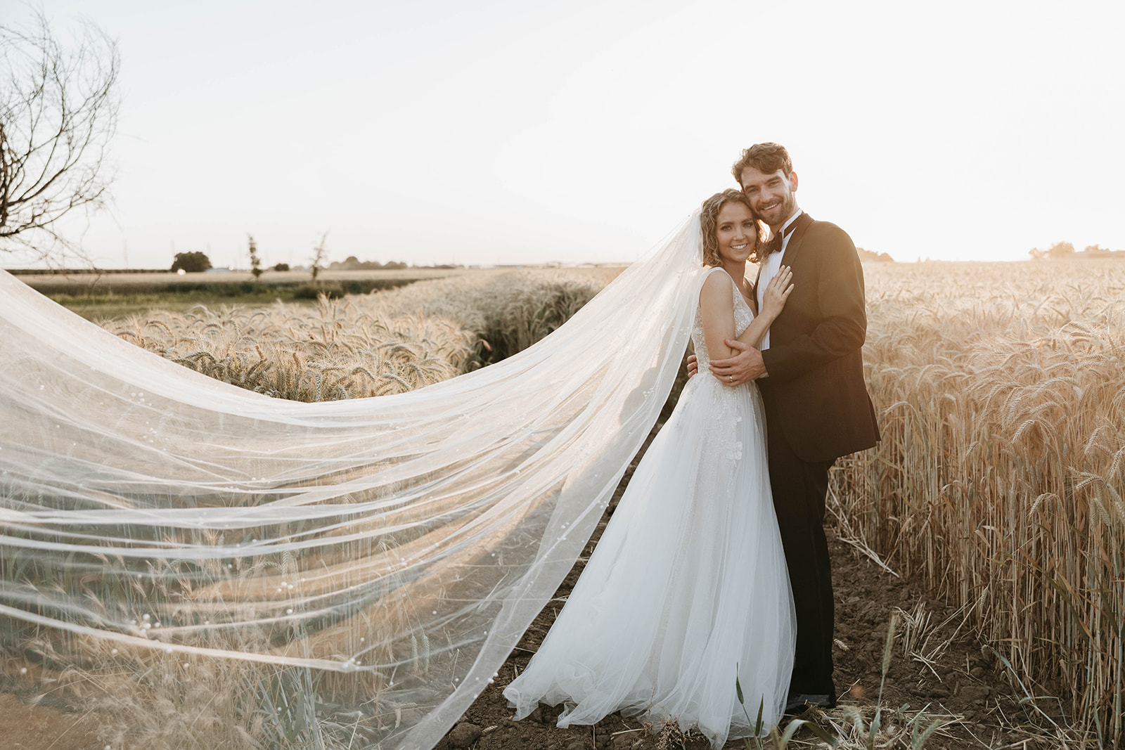 couple posing in a field in california for their wedding portraits