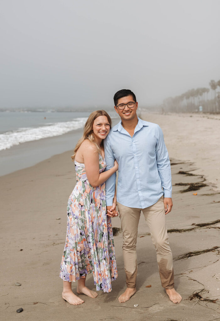 couple having a picnic on the beach in santa barbara during a surprise proposal photoshoot
