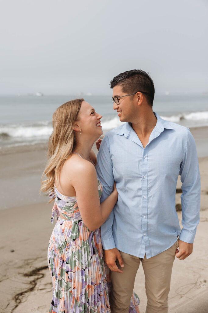 couple having a picnic on the beach in santa barbara during a surprise proposal photoshoot
