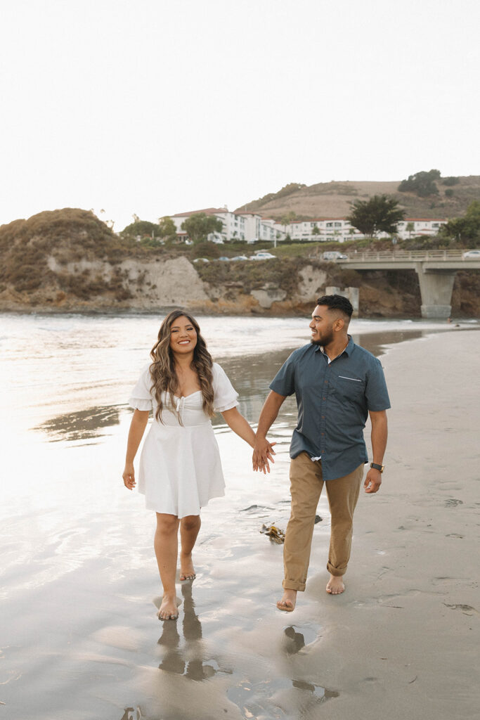 couple posing on a beach in central california for a photoshoot
