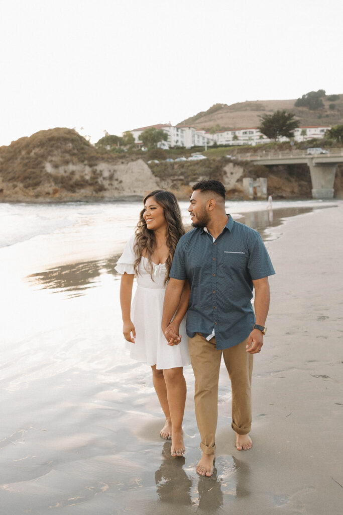 couple posing on a beach in central california for a photoshoot
