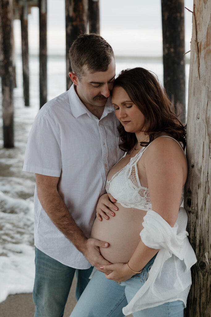 a family maternity photoshoot on the beach in california
