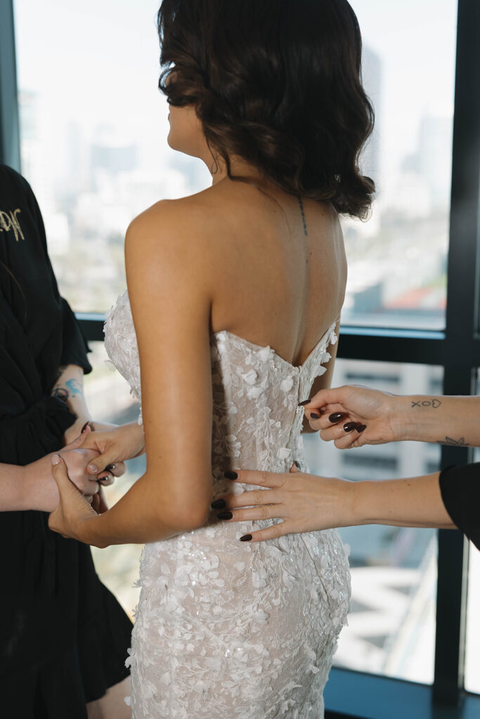 woman trying on her wedding gown
