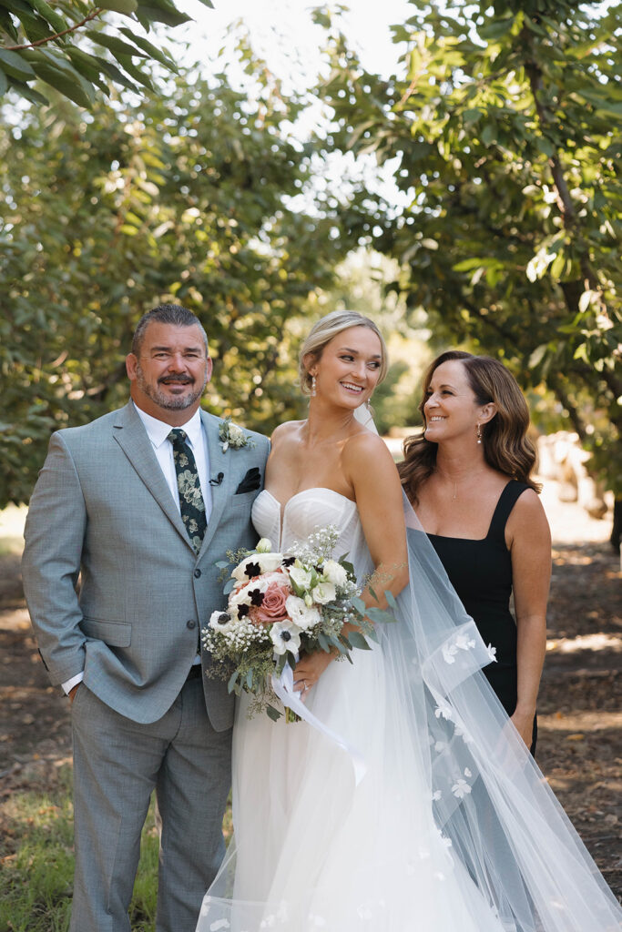 Bride with parents at Sacramento orchard wedding captured by Sacramento wedding photographer